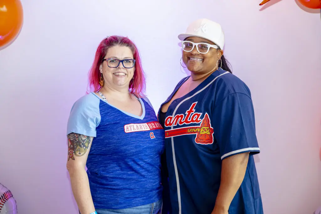 Two women pose wearing Braves t-shirts