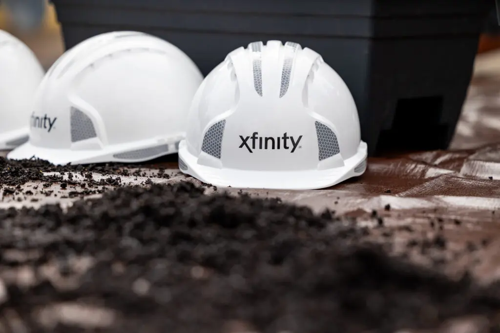 Xfinity and Comcast Business construction hats celebrating the network expansion.