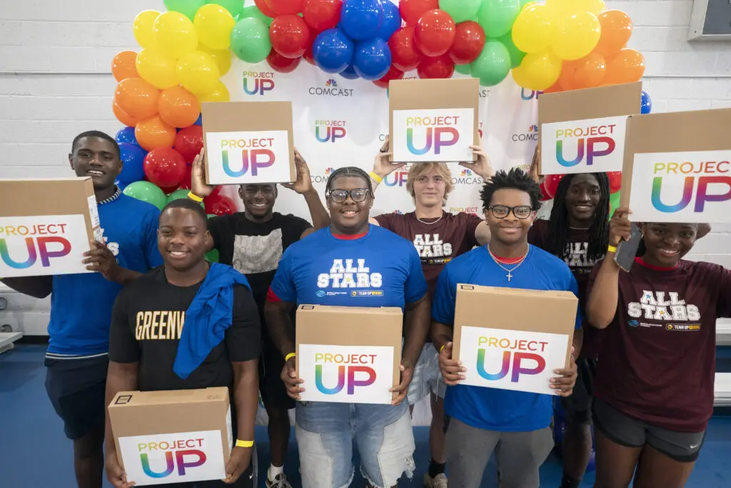 Students hold up gifted laptops during the Greenwood Comcast Expansion Rally at the the Boys & Girls Club Thursday May 22, 2025, in Greenwood, S.C.