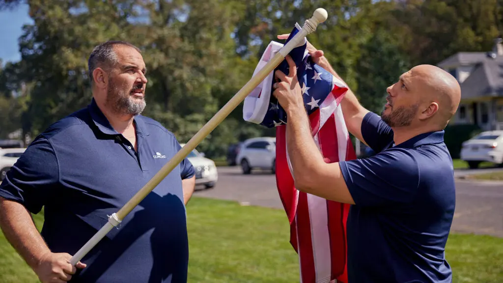 Comcast employees participate in Operation Old Glory, a flag replacement program