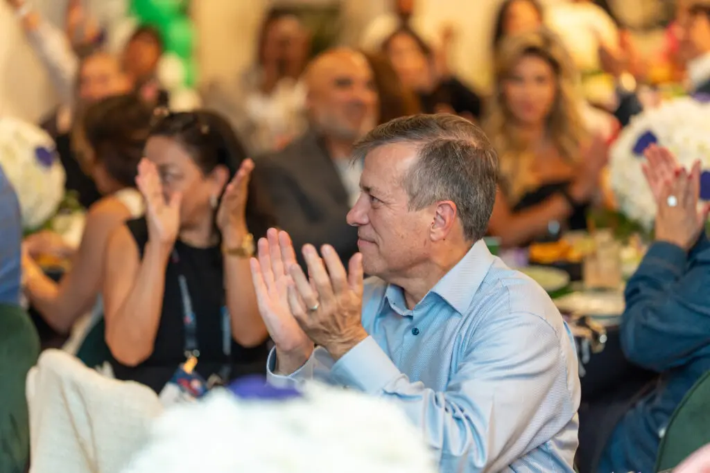 An attendee celebrates the launch of the World Soccer Ticket in Atlanta, applauding the initiative that brings fans closer to the global game through expanded access and community engagement.