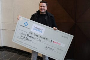 A Comcast Business and the Gwinnett Chamber of Commerce grant recipient holding a giant check.