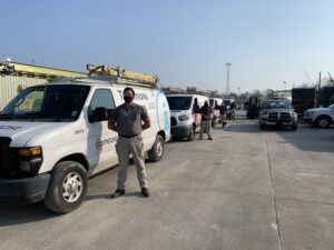 Xfinity technicians standing next to their service vehicles.