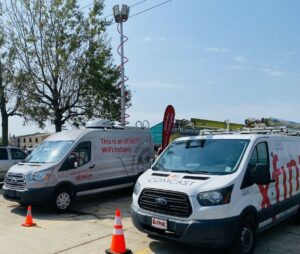 Xfinity technicians standing next to their service vehicles.