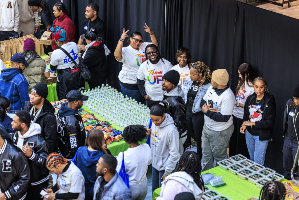 Comcast’s Team Up volunteers smile at Emerging 100 of Atlanta’s “One Roof” event for MLK Day.