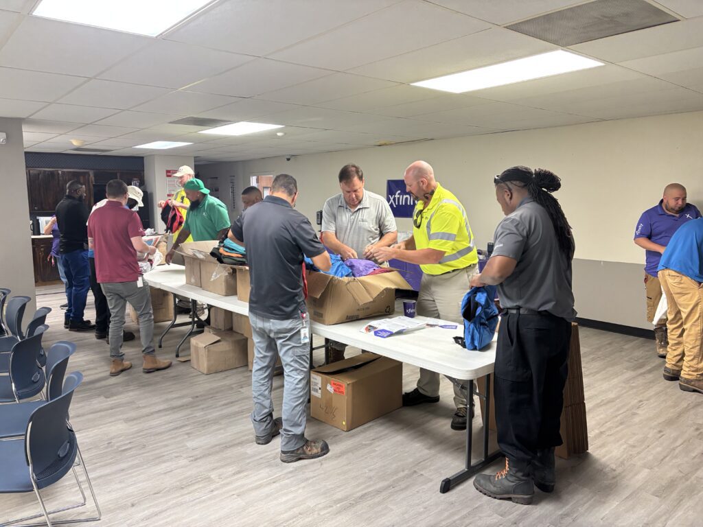 Comcast packs backpacks for the African American Parade Committee’s back-to-school drive, joined by Former State Representative Barbara Norton.