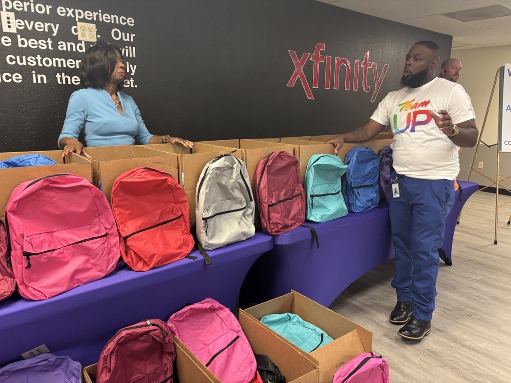 Comcast packs backpacks for the African American Parade Committee’s back-to-school drive, joined by Former State Representative Barbara Norton.