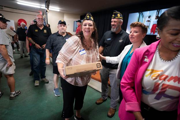 Members of American Legion Post 26 receive free laptops donated by Comcast during Lift Zone grand opening.